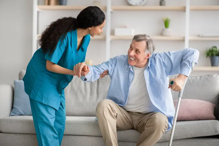 Nurse checking elderly patient's blood pressure at home